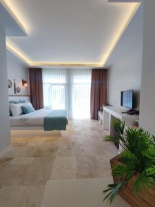 a large bedroom with a bed and a television at Mavi Cam Hotel Ayvalik in Sefaçamlık