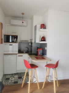 uma cozinha com duas cadeiras vermelhas e um balcão em CENTRE-CATHEDRALE-CORDELIERS avec garage em Reims