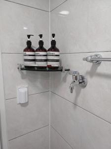 a bathroom with three bottles on a shelf in a shower at With us2 #sillim station #seowon station #netflix #wifi in Seoul