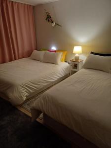 two beds in a bedroom with a lamp on a table at With us2 #sillim station #seowon station #netflix #wifi in Seoul