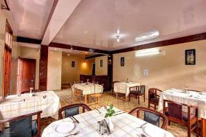 HOTEL NARAYAN MANALI في مانالي: غرفة طعام مع طاولات وكراسي في مطعم