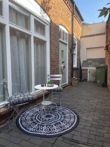 a patio with a table and two chairs on a patio at The Mews - Worcester City - Entire House - Gated - Self Check In - Free WIFI - 2 Doubles - Sleeps 6 - Cricket Club & Racecourse Close in Worcester