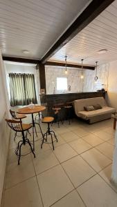 un soggiorno con tavolo, sedie e divano di Residência Saquarema a Saquarema
