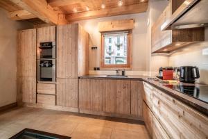 une cuisine avec des armoires en bois et un évier dans l'établissement Chalet Inari Chamonix - by EMERALD STAY, à Chamonix-Mont-Blanc 57 autres photos