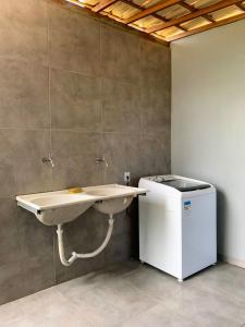 baño con lavabo y calentador de agua en Via Del Mare Flats, en Maraú