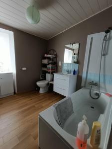 a bathroom with a tub and a sink and a toilet at Maison De Village in Barbechat