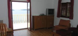 a living room with a television and a balcony at Vila Mia in Prizba