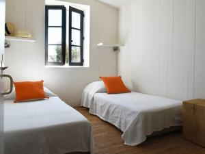 Les PortesにあるMaison Les Portes-en-Ré, 4 pièces, 6 personnes - FR-1-434-17のオレンジ枕付きのベッド2台が備わる客室です。