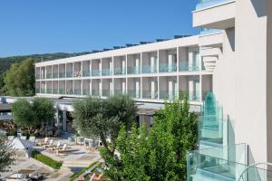 an exterior view of a hotel with a glass staircase at Amaronda Resort & Spa Eretria in Eretria