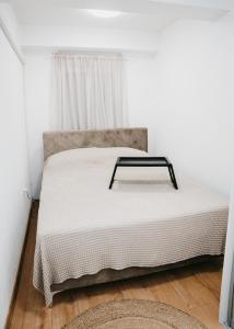 uma cama num quarto branco com uma mesa em Apartman FRIDAY em Travnik