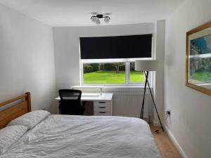 a bedroom with a bed and a desk and a window at Spacious - 3 double beds - Wi-Fi - Central Northwood - Free Parking in Northwood