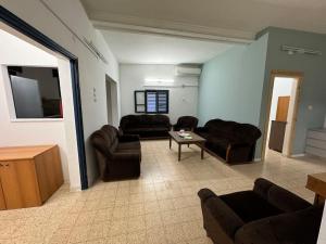 ‘Isfiyā的住宿－דירה עם נוף למפרץ חיפה עד החרמון，客厅配有两张沙发和一张桌子