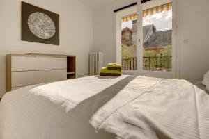 a white bed in a room with a window at Un Appart En Ville "O Fil de l'O" in Annecy