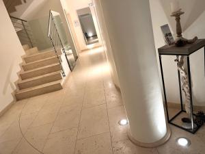 un couloir avec un escalier avec une colonne blanche et une table dans l'établissement Casa delle Nuvole e Casa del Tramonto, à Chioggia