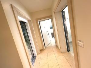 korytarz z dwoma drzwiami i podłogą wyłożoną kafelkami w obiekcie Casa delle Nuvole e Casa del Tramonto w mieście Chioggia