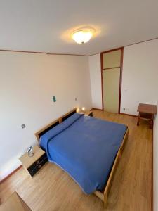 een slaapkamer met een blauw bed in een kamer bij Riviera Complex in Lignano Sabbiadoro