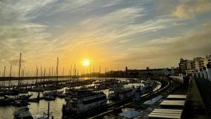 un grupo de barcos estacionados en un puerto deportivo al atardecer en Change The World Hostels - Açores - Ponta Delgada, en Ponta Delgada