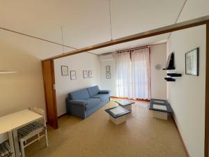 een woonkamer met een blauwe bank en een tafel bij Riviera Complex in Lignano Sabbiadoro
