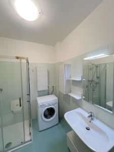 een badkamer met een wasmachine en een wastafel bij Riviera Complex in Lignano Sabbiadoro