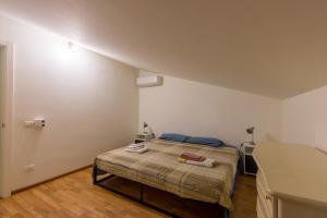 um quarto com uma cama num quarto branco em Casa del Glicine em Marina di Ragusa