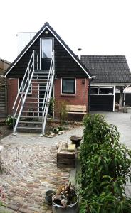 une maison en briques avec un escalier en face de celle-ci dans l'établissement Suuthwalda Overnight Stay, à Zuidwolde