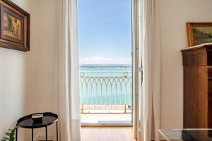 um quarto com uma porta aberta para uma vista para o oceano em Seaview Design Homes in Ortigia by Wonderful Italy em Siracusa