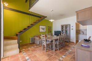 uma cozinha e sala de jantar com uma mesa e uma escada em Casa del Glicine em Marina di Ragusa
