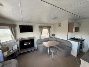 a living room with a table and a kitchen in a caravan at 28 Trent view in Cottam