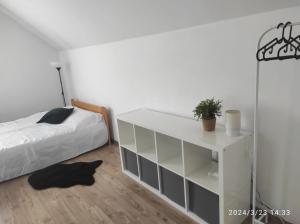a bedroom with a white bed and a white cabinet at Domek w górach in Sucha Beskidzka