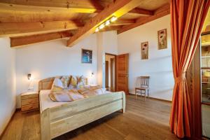 a bedroom with a bed in a room with wooden ceilings at Schnatzhof Apartment Adlerhorst in Naturno