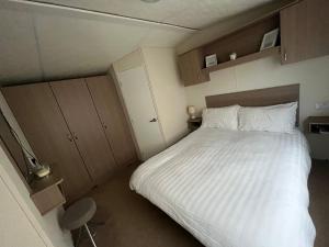 een slaapkamer met een groot bed met witte lakens bij 28 Trent view in Cottam