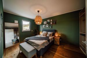 ein Schlafzimmer mit einem Bett und einer grünen Wand in der Unterkunft Modern Apartm. Wanderlust with Home Cinema in Echternacherbrück
