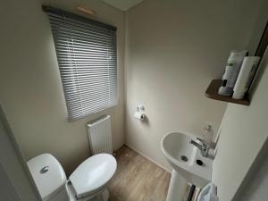 een witte badkamer met een toilet en een wastafel bij 28 Trent view in Cottam