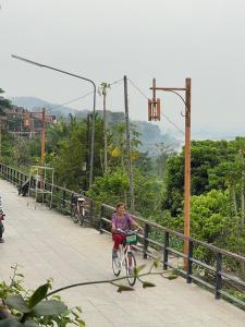 a woman riding a bike on a bridge at The White House in Chiang Khan
