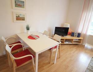 ニーンドルフにあるApartmentvermittlung Mehr als Meer - Objekt 6の白いテーブルと椅子、テレビが備わる客室です。