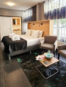 ファルケンブルグにあるVilla Valkenburgのベッド、椅子、テーブルが備わるホテルルームです。