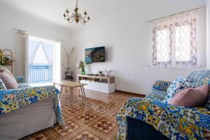 a living room with two chairs and a table at Mimì Junior home, central sea view apartment in Praiano