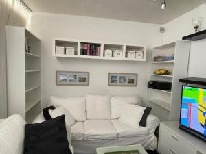 a living room with a white couch and a tv at VS-Guesthouse in Copenhagen