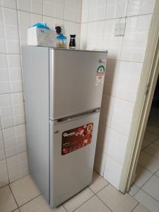 einen weißen Kühlschrank in einer Küche neben einer Wand in der Unterkunft Peridot Suites in Nairobi