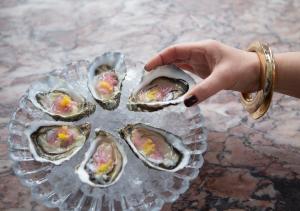 a person pointing at a plate of oysters on ice at Görvälns Slott in Järfälla