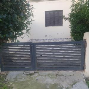 een poort voor een wit gebouw met een raam bij Maison de vacances à la mer 5mn à pieds in Borj el Khessous