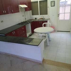 eine Küche mit einer Theke und einem Tisch darin in der Unterkunft Maison de vacances à la mer 5mn à pieds in Borj el Khessous