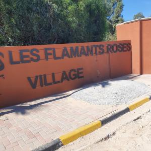 a sign that reads less flamingiantsrosis village at Maison de vacances à la mer 5mn à pieds in Borj el Khessous