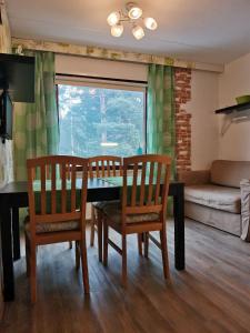 uma sala de jantar com uma mesa e cadeiras e um sofá em Boho Apart Ututie em Kotka