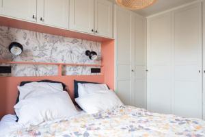 Schlafzimmer mit einem Bett mit einem orangefarbenen Kopfteil in der Unterkunft Beautiful family home in Boulogne-Billancourt in Boulogne-Billancourt