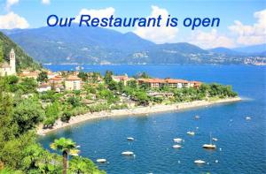 an island in a body of water with boats at Hotel La Rondinella in Cannero Riviera