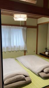 a bedroom with a large bed with a window at SIBARIAN Guest House in Kaga