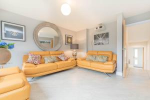 a living room with two couches and a mirror at High Tide in Whitstable