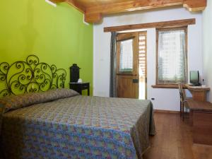 1 dormitorio con cama y pared verde en B&B Cascina dell'eco, en Busca