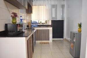 a kitchen with a microwave and a refrigerator at Juliett Wonder Furnished Apartment in Nairobi